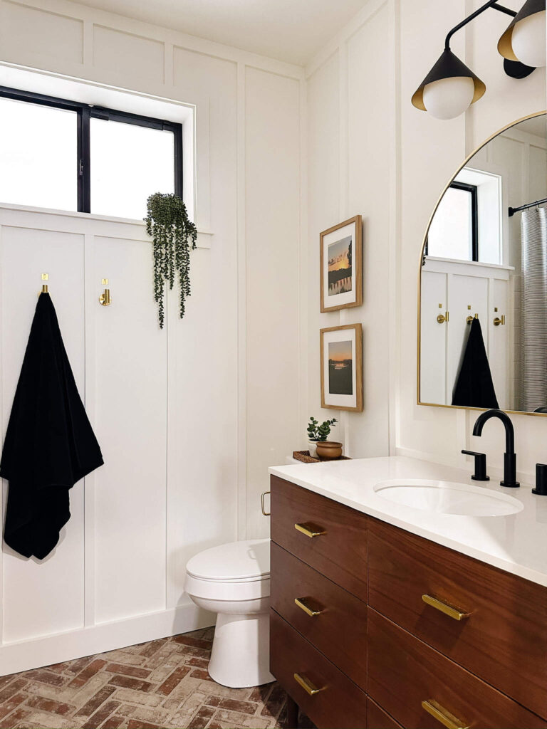 Freshly renovated guest bathroom with new vanity, toliet, window, and decor.