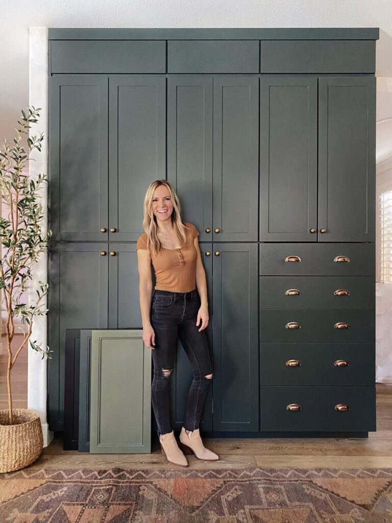 Angela Rose standing in front of dark green Nieu cabinets.