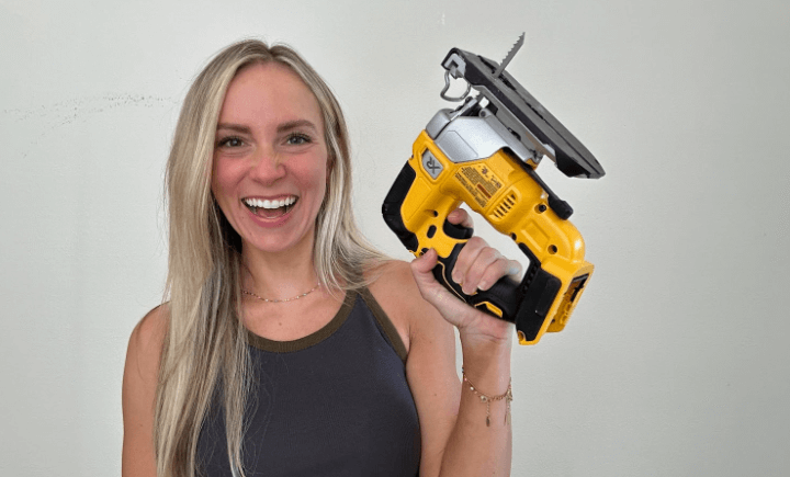 Angela Rose holding a Dewalt jigsaw.