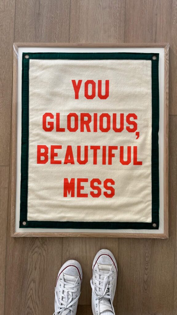 A quote in a frame that says, You glorious, beautiful mess.