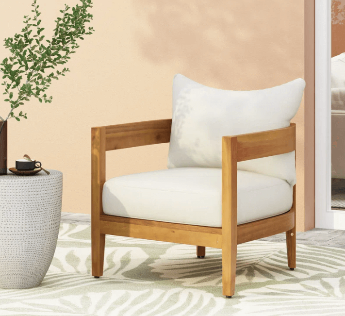 beige outdoor chair with wooden legs and arms.