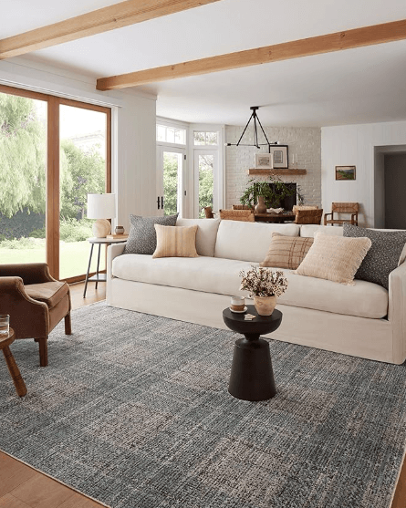 Denim/charcoal colored rug staged in a living room.