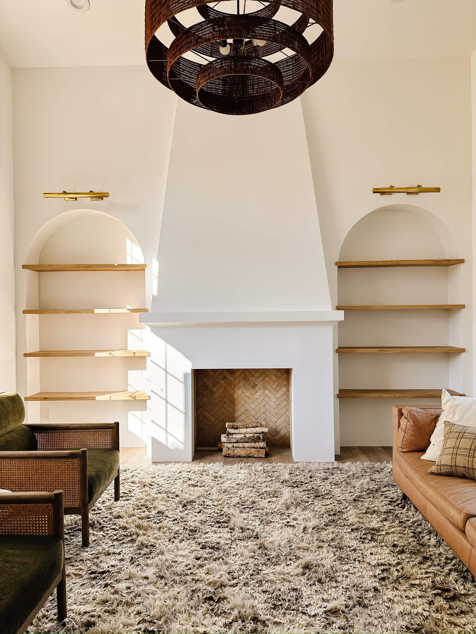 Angela Rose's front room featuring a remodeled fireplace and mantle, and arches on either side with floating shelves.