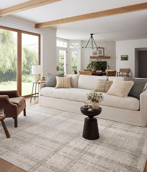 Layered fall home decor with ghost blanket, ivory rug, and plum garland for cozy autumn living.